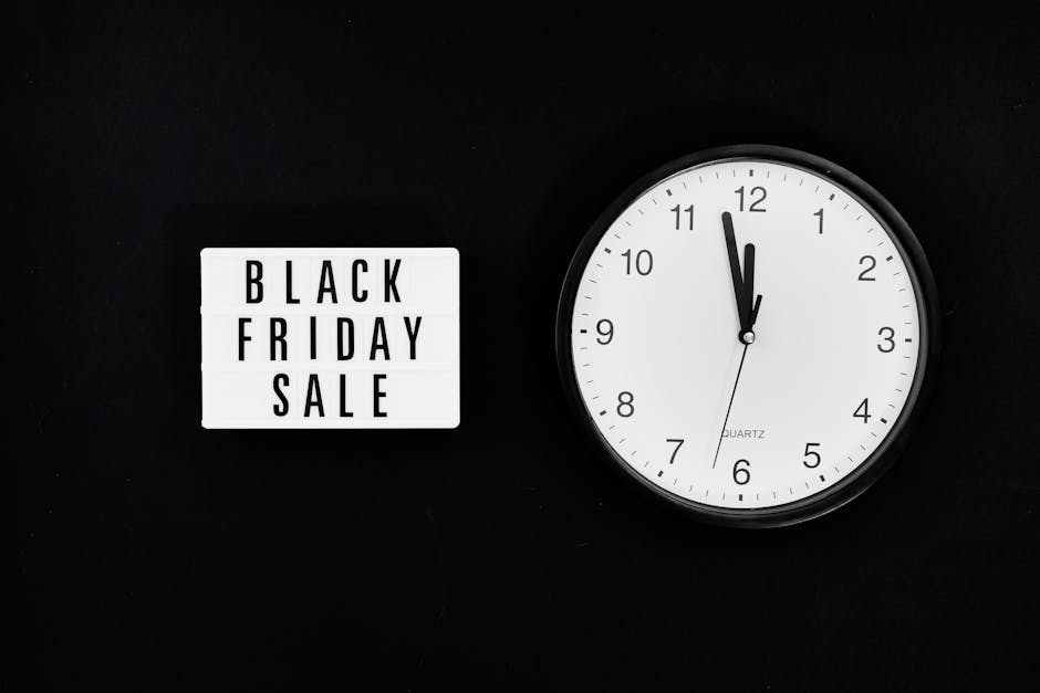A black wall background featuring a white letterboard displaying the text 'BLACK FRIDAY SALE' in black capital letters, positioned to the left. To the right, there is a white analog clock with black h